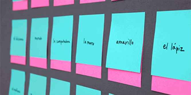 Un mur recouvert de notes Post-it® comportant des mots espagnols, utilisés pour pratiquer la langue
