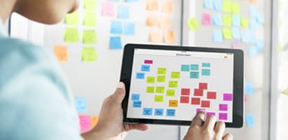 Une jeune femme qui utilise l'application pour réaliser un tableau Kanban.