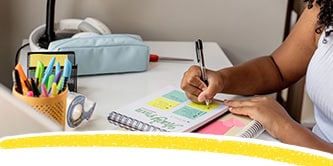 Un étudiant prenant des notes sur des Notes Post-it®
