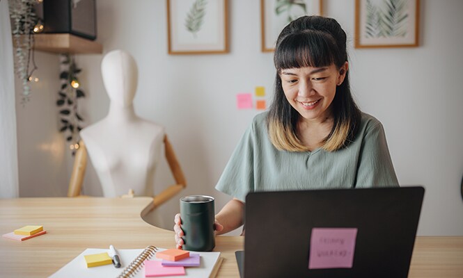 Femme assise à un bureau dans un espace chaleureux et organisé, entourée de décoration
